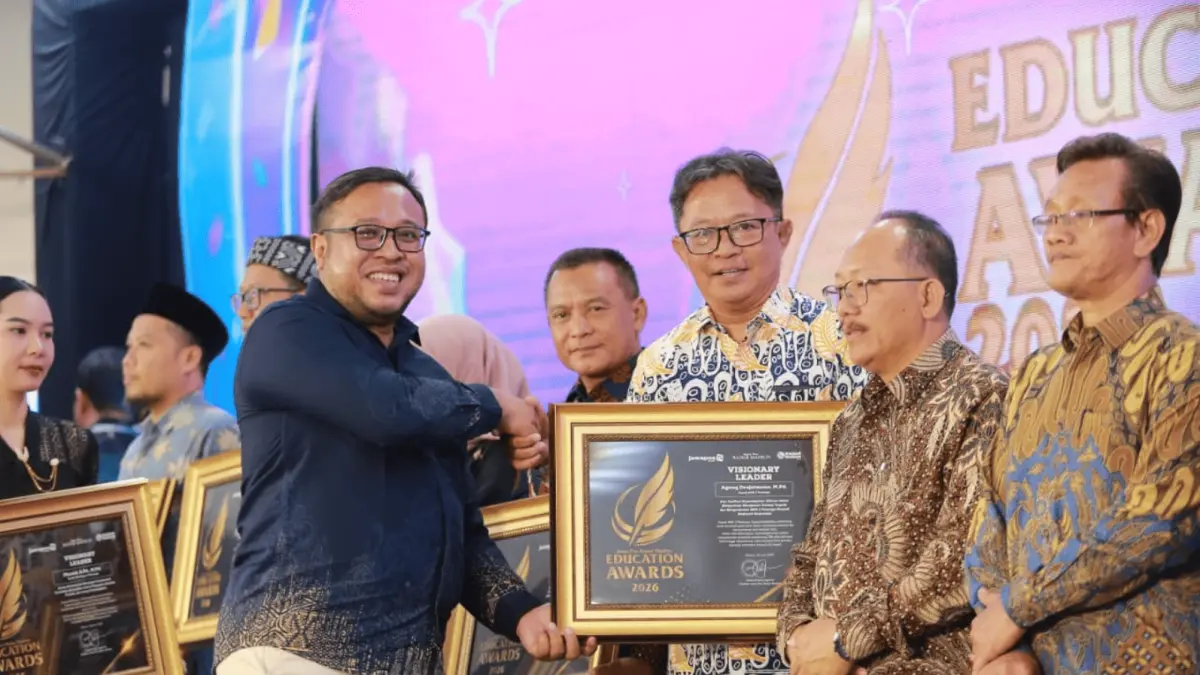 Direktur Jawa Pos Radar Madiun Ockta Prana Lagawira menyerahkan penghargaan Visionary Leader kepada Kepala MAN 2 Ponorogo Agung Drajatmono dalam ajang Radar Madiun Education Awards 2026, Minggu (28/6). (BAGAS BIMANTARA/RADAR MADIUN)