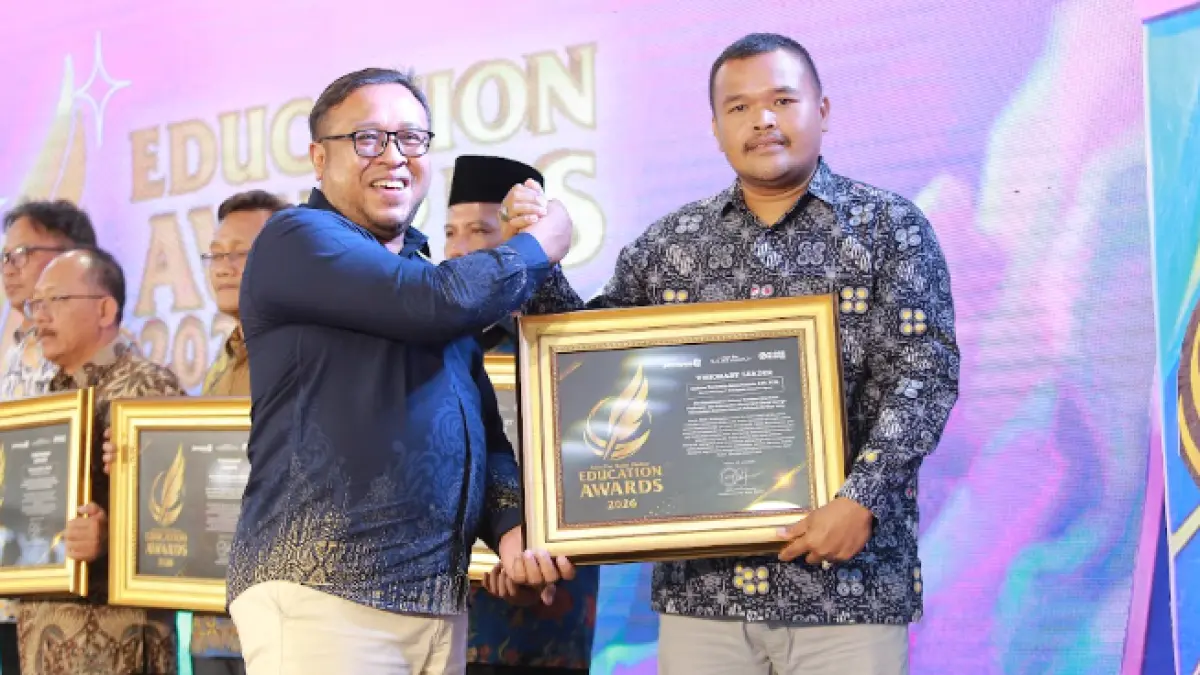 Direktur Jawa Pos Radar Madiun Ockta Prana Lagawira menyerahkan penghargaan Visionary Leader kepada Kepala SMAN 1 Kedunggalar Andrias Marstanto Setyo Pranoto dalam ajang Radar Madiun Education Awards 2026, Minggu (28/6). (BAGAS BIMANTARA/RADAR MADIUN)