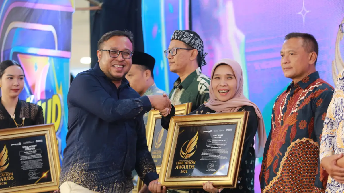 Direktur Jawa Pos Radar Madiun Ockta Prana Lagawira menyerahkan penghargaan Visionary Leader kepada Kepala SMAN 3 Magetan Riful Hamidah dalam ajang Radar Madiun Education Awards 2026, Minggu (28/6). (BAGAS BIMANTARA/RADAR MADIUN)