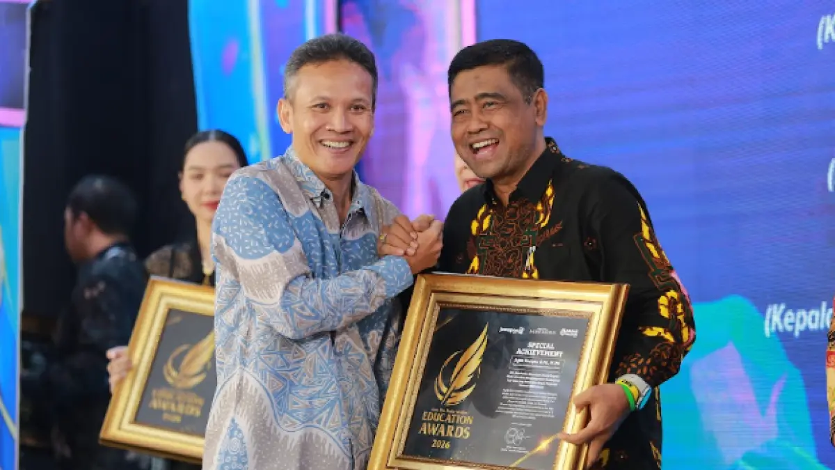 Direktur Jawa Pos Radar Marsudi Nurwahid menyerahkan penghargaan Special Achievement kepada Kepala Dikbud Kabupaten Madiun Agus Sucipto dalam ajang Radar Madiun Education Awards 2026, Minggu (28/6). (BAGAS BIMANTARA/RADAR MADIUN)