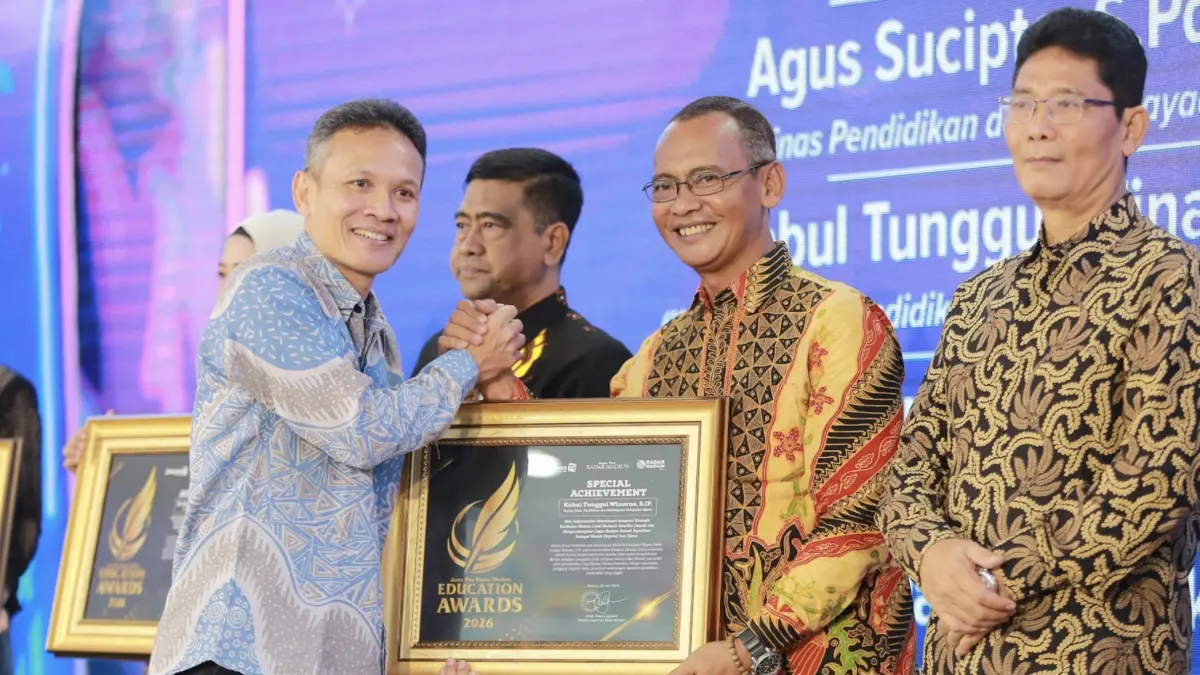 Direktur Jawa Pos Radar Marsudi Nurwahid menyerahkan penghargaan Special Achievement kepada Kepala Dikbud Ngawi Kabul Tunggul Winarno dalam ajang Radar Madiun Education Awards 2026, Minggu (28/6). (BAGAS BIMANTARA/RADAR MADIUN)