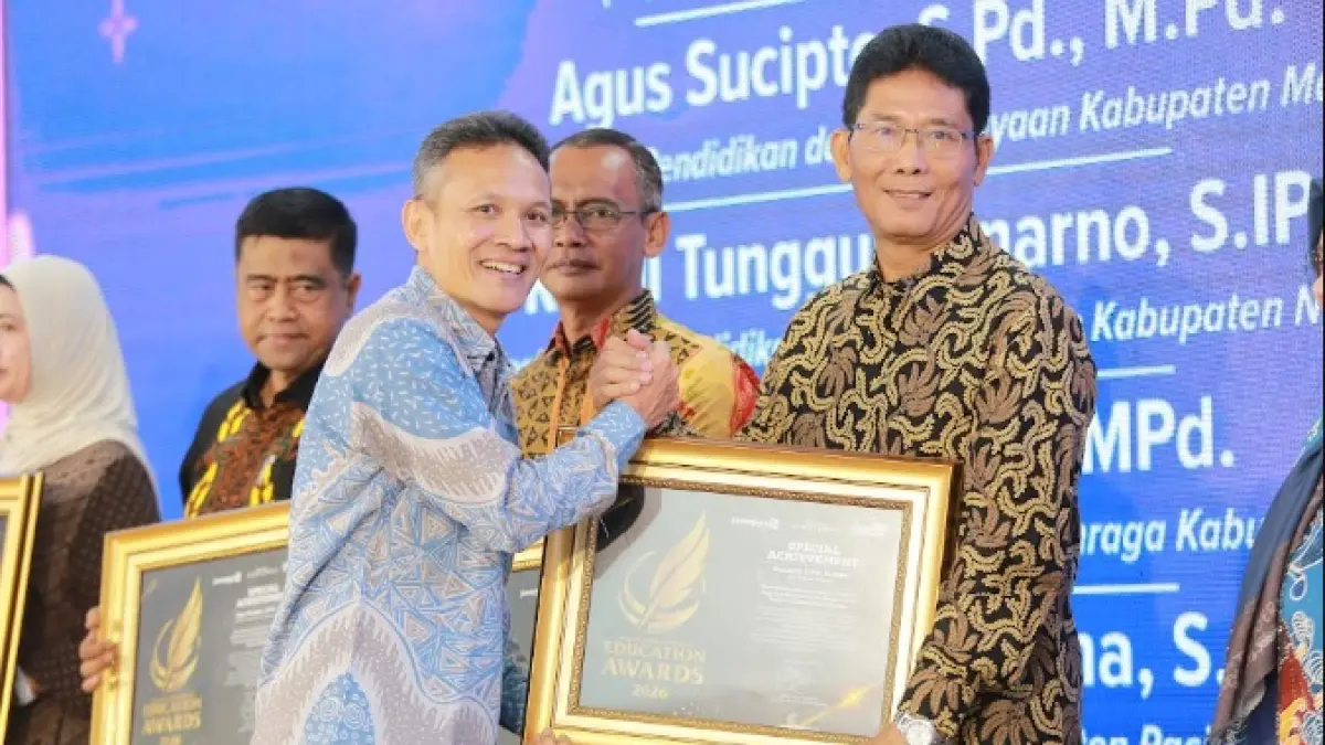 Direktur Jawa Pos Radar Marsudi Nurwahid menyerahkan penghargaan Special Achievement kepada Kepala Dikpora Magetan Suhardi dalam ajang Radar Madiun Education Awards 2026, Minggu (28/6). (BAGAS BIMANTARA/RADAR MADIUN)
