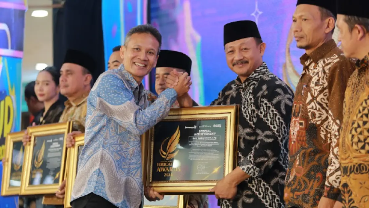 Direktur Jawa Pos Radar Marsudi Nurwahid menyerahkan penghargaan Special Achievement kepada Kepala Kantor Kemenag Magetan Taufiqurrohman dalam ajang Radar Madiun Education Awards 2026, Minggu (28/6). (BAGAS BIMANTARA/RADAR MADIUN)