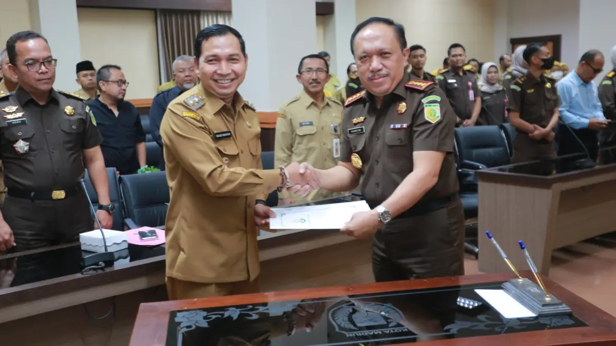 SERAH TERIMA ASET: Kajari Kota Madiun Komaidi menyerahkan sertifikat hasil sita eksekusi aset PSU Perumahan Puri Asri Lestari kepada Plt Wali Kota Madiun F. Bagus Panuntun sebagai aset milik daerah. BAGAS BIMANTARA/RADAR MADIUN