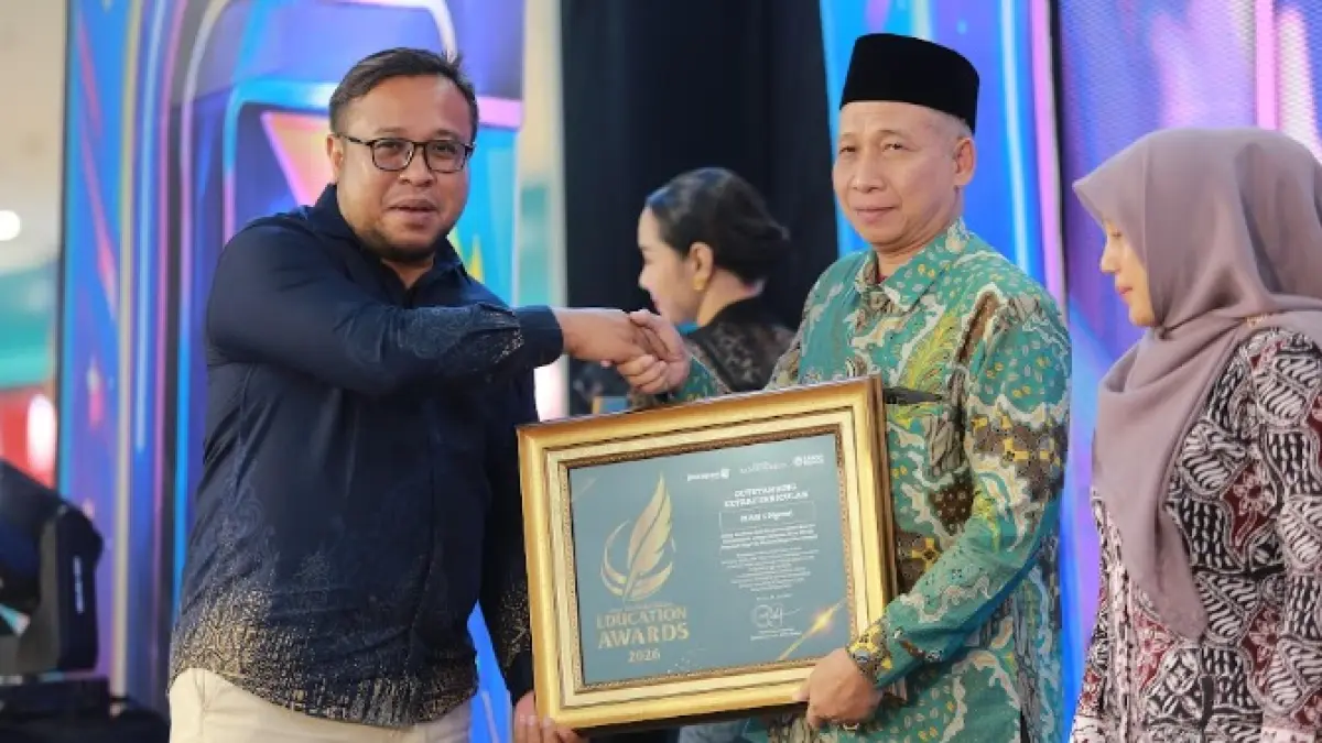 Direktur Jawa Pos Radar Madiun Ockta Prana menyerahkan penghargaan Digital Transformation kepada Kepala MAN 1 Ngawi Maskur dalam Radar Madiun Education Awards 2026, Minggu (28/6). (BAGAS BIMANTARA/RADAR MADIUN)