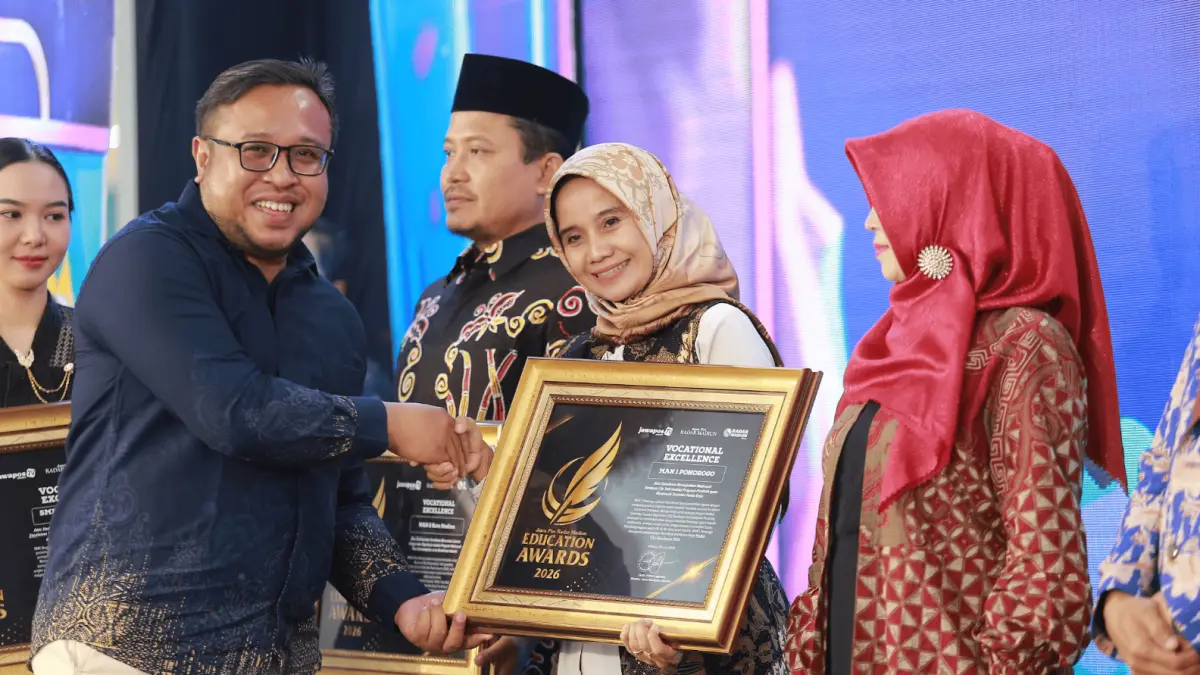 Direktur Jawa Pos Radar Madiun Ockta Prana menyerahkan penghargaan Digital Transformation kepada Kepala MAN 1 Ponorogo Nuurun Nahdiyyah dalam Radar Madiun Education Awards 2026, Minggu (28/6). (BAGAS BIMANTARA/RADAR MADIUN)
