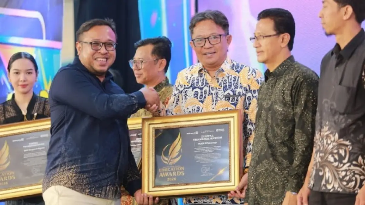 Direktur Jawa Pos Radar Madiun Ockta Prana menyerahkan penghargaan Digital Transformation kepada Kepala MAN 2 Ponorogo Agung Drajatmono dalam Radar Madiun Education Awards 2026, Minggu (28/6).