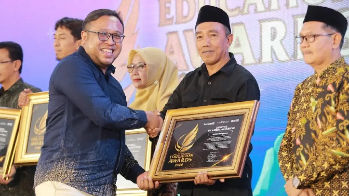 Direktur Jawa Pos Radar Madiun Ockta Prana menyerahkan penghargaan Digital Transformation kepada Kepala MIN 3 Magetan Kushadi Santoso dalam Radar Madiun Education Awards 2026, Minggu (28/6). (BAGAS BIMANTARA/RADAR MADIUN)