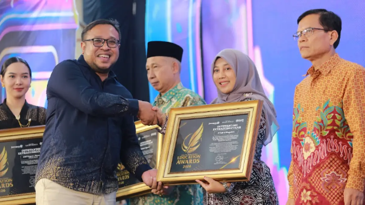 Direktur Jawa Pos Radar Madiun Ockta Prana menyerahkan penghargaan Digital Transformation kepada Kepala MTsN 3 Magetan, Susilowati dalam Radar Madiun Education Awards 2026, Minggu (28/6). (BAGAS BIMANTARA/RADAR MADIUN)