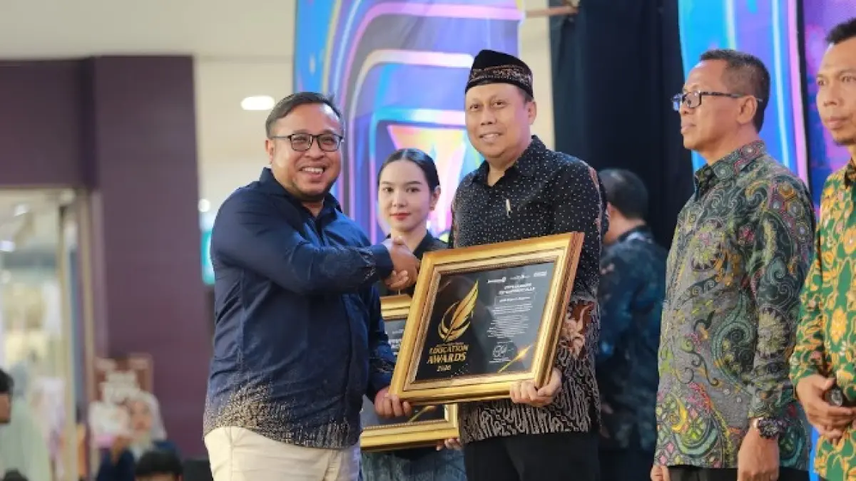 Direktur Jawa Pos Radar Madiun Ockta Prana menyerahkan penghargaan Digital Transformation kepada Kepala SMAN 1 Magetan Aris Sudarmono dalam Radar Madiun Education Awards 2026, Minggu (28/6). (BAGAS BIMANTARA/RADAR MADIUN)