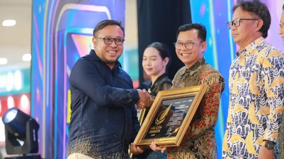 Direktur Jawa Pos Radar Madiun Ockta Prana menyerahkan penghargaan Digital Transformation kepada Kepala SMAN 2 Madiun Anim Hadisusanto dalam Radar Madiun Education Awards 2026, Minggu (28/6). (BAGAS BIMANTARA/RADAR MADIUN)