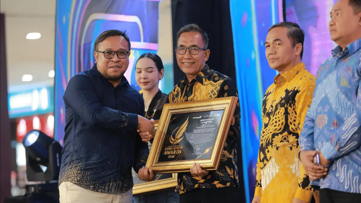 Direktur Jawa Pos Radar Madiun Ockta Prana menyerahkan penghargaan Digital Transformation kepada Kepala SMAN 3 Taruna Angkasa Jawa Timur Agus Supriyono dalam Radar Madiun Education Awards 2026, Minggu (28/6). (BAGAS BIMANTARA/RADAR MADIUN)