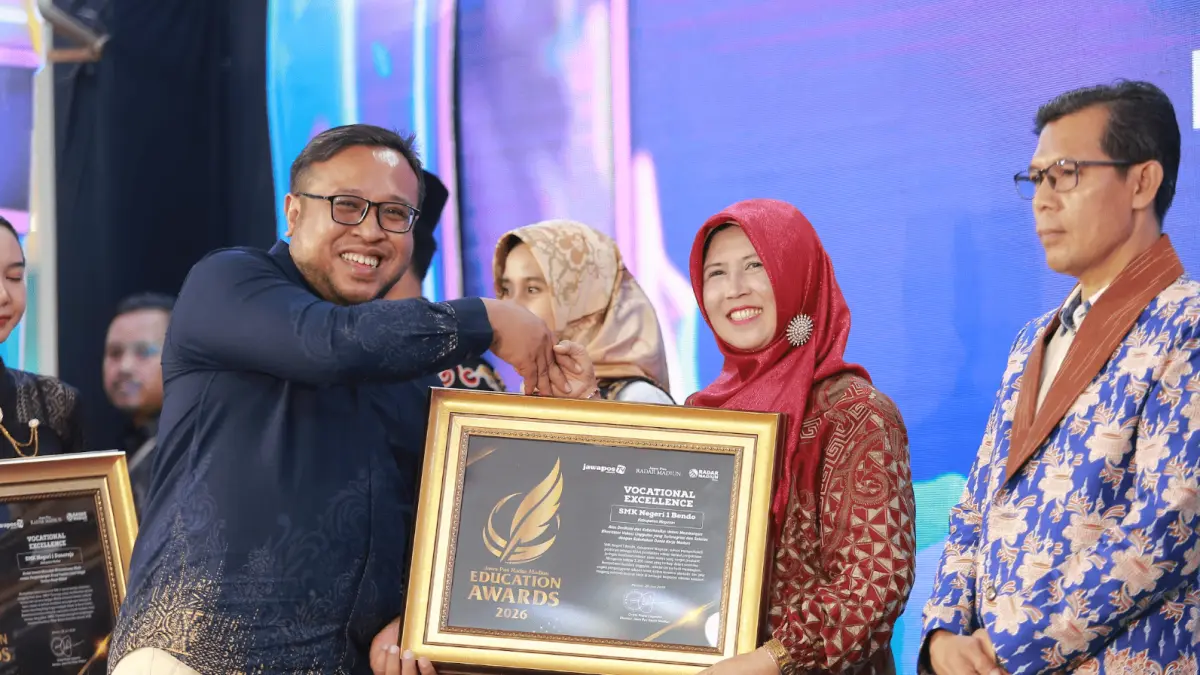 Direktur Jawa Pos Radar Madiun Ockta Prana menyerahkan penghargaan Digital Transformation kepada Kepala SMKN 1 Bendo, Yayuk Sri Rahayu Wahyuningsih dalam Radar Madiun Education Awards 2026, Minggu (28/6). (BAGAS BIMANTARA/RADAR MADIUN)