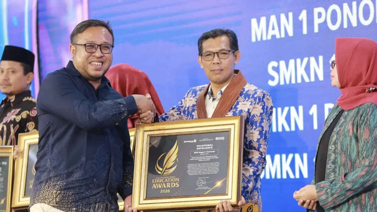 Direktur Jawa Pos Radar Madiun Ockta Prana menyerahkan penghargaan Digital Transformation kepada Kepala SMKN 1 Donorojo, Achmad Syaifudin dalam Radar Madiun Education Awards 2026, Minggu (28/6). (BAGAS BIMANTARA/RADAR MADIUN)