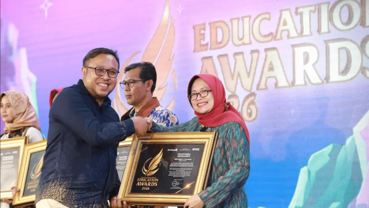 Direktur Jawa Pos Radar Madiun Ockta Prana menyerahkan penghargaan Digital Transformation kepada Kepala SMKN 1 Jenangan Farida Hanim Handayani dalam Radar Madiun Education Awards 2026, Minggu (28/6). (BAGAS BIMANTARA/RADAR MADIUN)