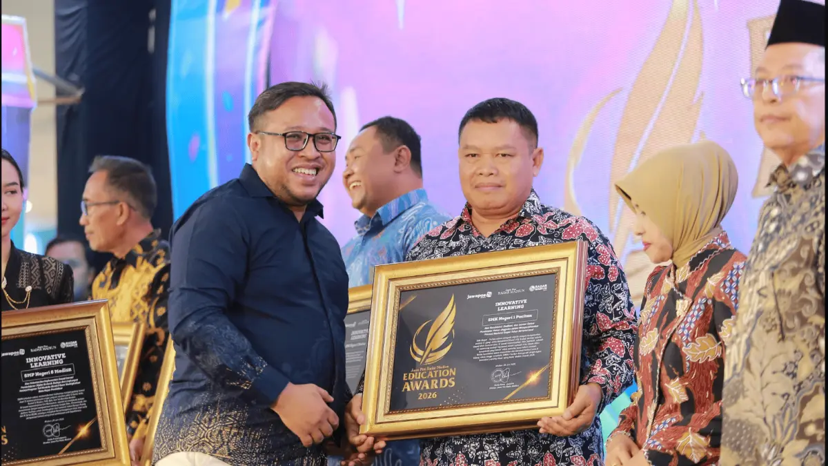 Direktur Jawa Pos Radar Madiun Ockta Prana menyerahkan penghargaan Digital Transformation kepada Kepala SMKN 1 Pacitan Joko Supriyadi dalam Radar Madiun Education Awards 2026, Minggu (28/6). (BAGAS BIMANTARA/RADAR MADIUN)