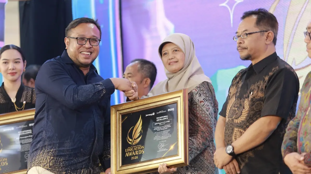 Direktur Jawa Pos Radar Madiun Ockta Prana menyerahkan penghargaan Digital Transformation kepada Kepala SMKN 2 Donorojo, Endang Agustini dalam Radar Madiun Education Awards 2026, Minggu (28/6). (BAGAS BIMANTARA/RADAR MADIUN)