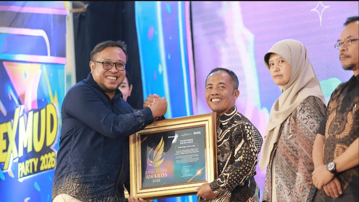 Direktur Jawa Pos Radar Madiun Ockta Prana menyerahkan penghargaan Digital Transformation kepada Kepala SMKN 2 Ponorogo Suryanto dalam Radar Madiun Education Awards 2026, Minggu (28/6). (BAGAS BIMANTARA/RADAR MADIUN)