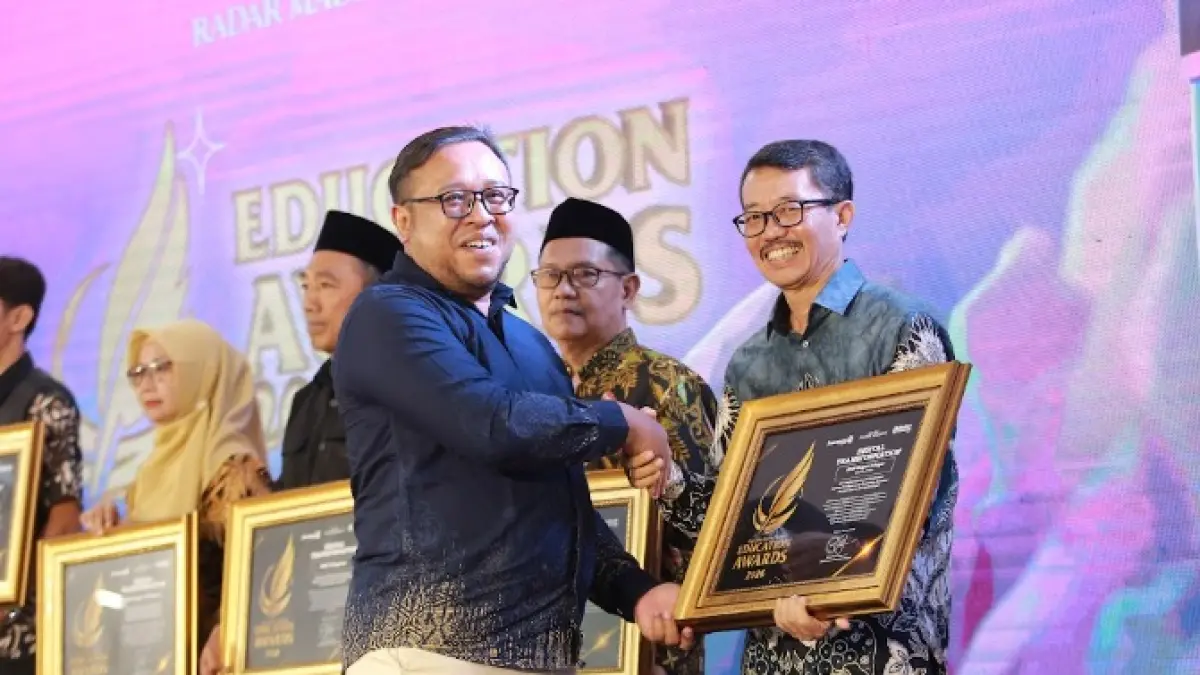 Direktur Jawa Pos Radar Madiun Ockta Prana menyerahkan penghargaan Digital Transformation kepada Kepala SMPN 1 Geger Pang Sugiharto dalam Radar Madiun Education Awards 2026, Minggu (28/6). (BAGAS BIMANTARA/RADAR MADIUN)