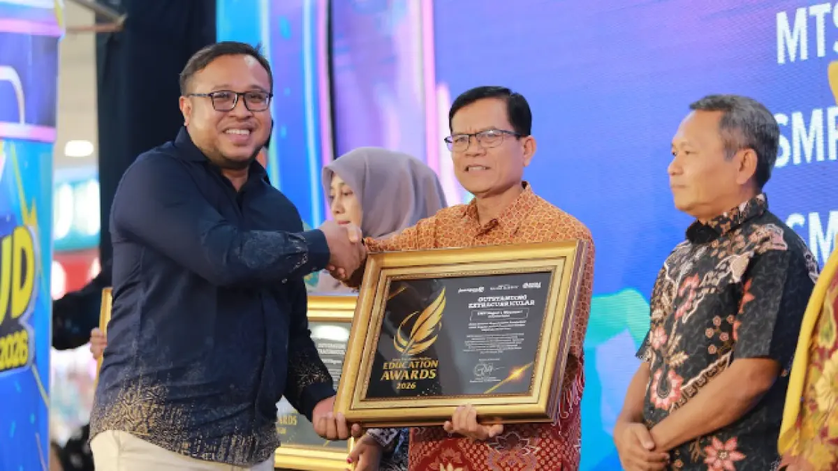 Direktur Jawa Pos Radar Madiun Ockta Prana menyerahkan penghargaan Digital Transformation kepada Kepala SMPN 1 Wonoasri Elly Ernaningsih  dalam Radar Madiun Education Awards 2026, Minggu (28/6). (BAGAS BIMANTARA/RADAR MADIUN)
