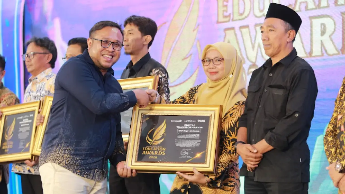 Direktur Jawa Pos Radar Madiun Ockta Prana menyerahkan penghargaan Digital Transformation kepada Kepala SMPN 13 Madiun Anik Suyatni dalam Radar Madiun Education Awards 2026, Minggu (28/6). (BAGAS BIMANTARA/RADAR MADIUN)