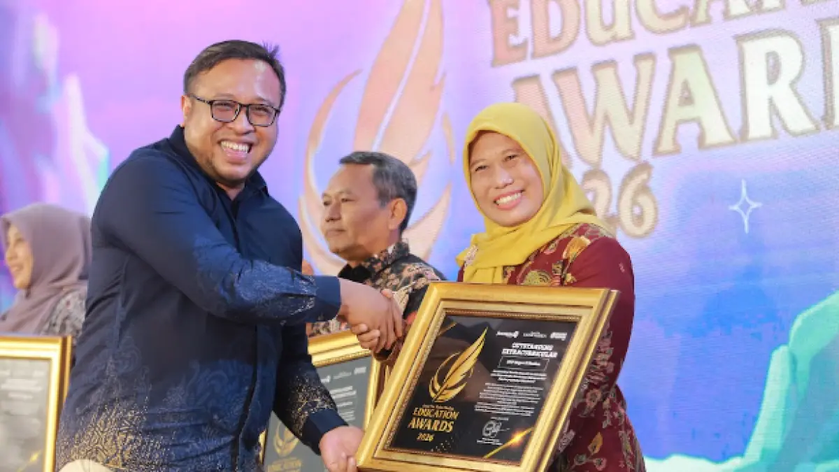 Direktur Jawa Pos Radar Madiun Ockta Prana menyerahkan penghargaan Digital Transformation kepada Kepala SMPN 5 Madiun, Ruspeniati dalam Radar Madiun Education Awards 2026, Minggu (28/6). (BAGAS BIMANTARA/RADAR MADIUN)
