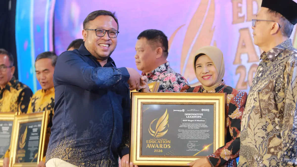 Direktur Jawa Pos Radar Madiun Ockta Prana menyerahkan penghargaan Digital Transformation kepada Kepala SMPN 6 Madiun Emi Munawaroh dalam Radar Madiun Education Awards 2026, Minggu (28/6). (BAGAS BIMANTARA/RADAR MADIUN)
