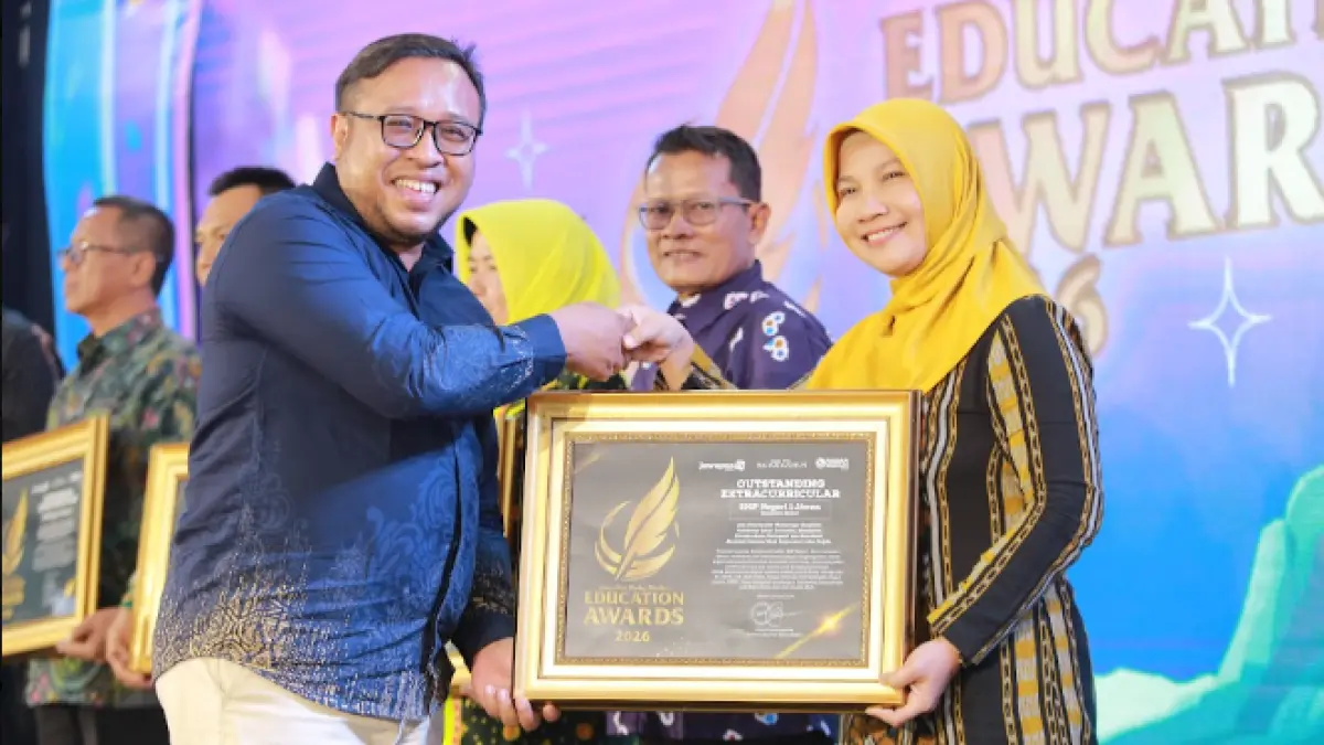 Direktur Jawa Pos Radar Madiun Ockta Prana menyerahkan penghargaan Digital Transformation kepada Plt. Kepala SMPN 1 Jiwan, Rochmawati Fadilah. dalam Radar Madiun Education Awards 2026, Minggu (28/6). (BAGAS BIMANTARA/RADAR MADIUN)