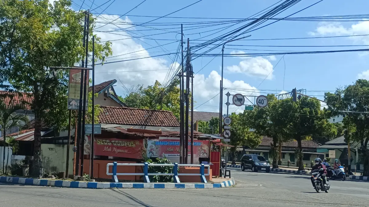 Kabel fiber optik yang membentang dan menjuntai di kawasan Perempatan Penceng, Pacitan, dikeluhkan warga karena mengganggu estetika kota dan dinilai berpotensi membahayakan pengguna jalan. NUR CAHYONO/RADAR PACITAN