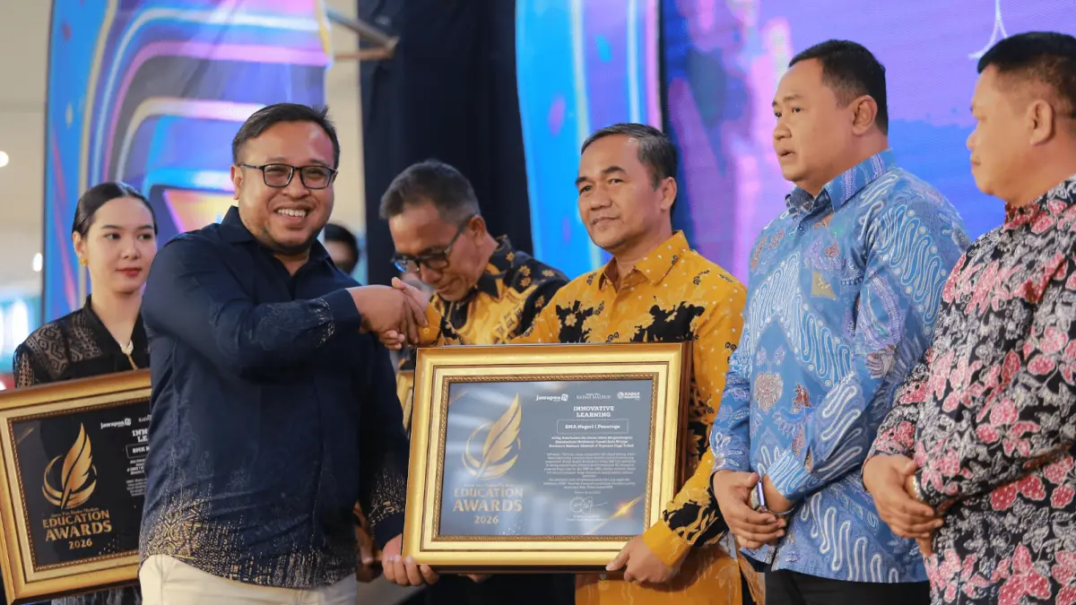 Kepala SMAN 1 Ponorogo Supardi menerima penghargaan Innovative Learning dari Direktur Jawa Pos Radar Madiun Ockta Prana Lagawira dalam Radar Madiun Education Awards 2026. (BAGAS BIMANTARA/RADAR MADIUN)