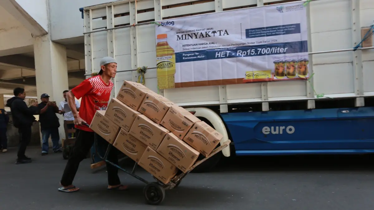 Petugas Bulog menyalurkan MinyaKita kepada pedagang di Pasar Besar Madiun sebagai upaya menjaga stok dan stabilitas harga minyak goreng sesuai HET. BAGAS BIMANTARA/RADAR MADIUN