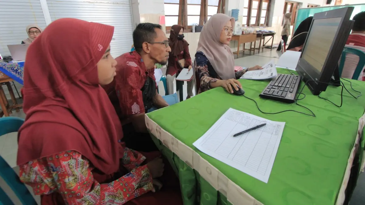 Petugas melayani proses Seleksi Penerimaan Murid Baru (SPMB) di salah satu SMP negeri di Magetan. AJI PUTRA/RADAR MAGETAN