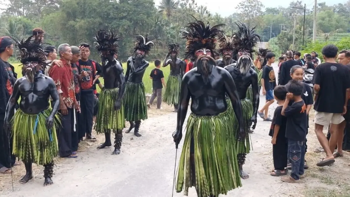 TRADISIONAL: Pelestari Tari Keling menghitamkan tubuh menggunakan campuran arang dan minyak kelapa sebelum tampil di Dusun Mojo, Desa Singgahan, Kecamatan Pulung, Ponorogo.