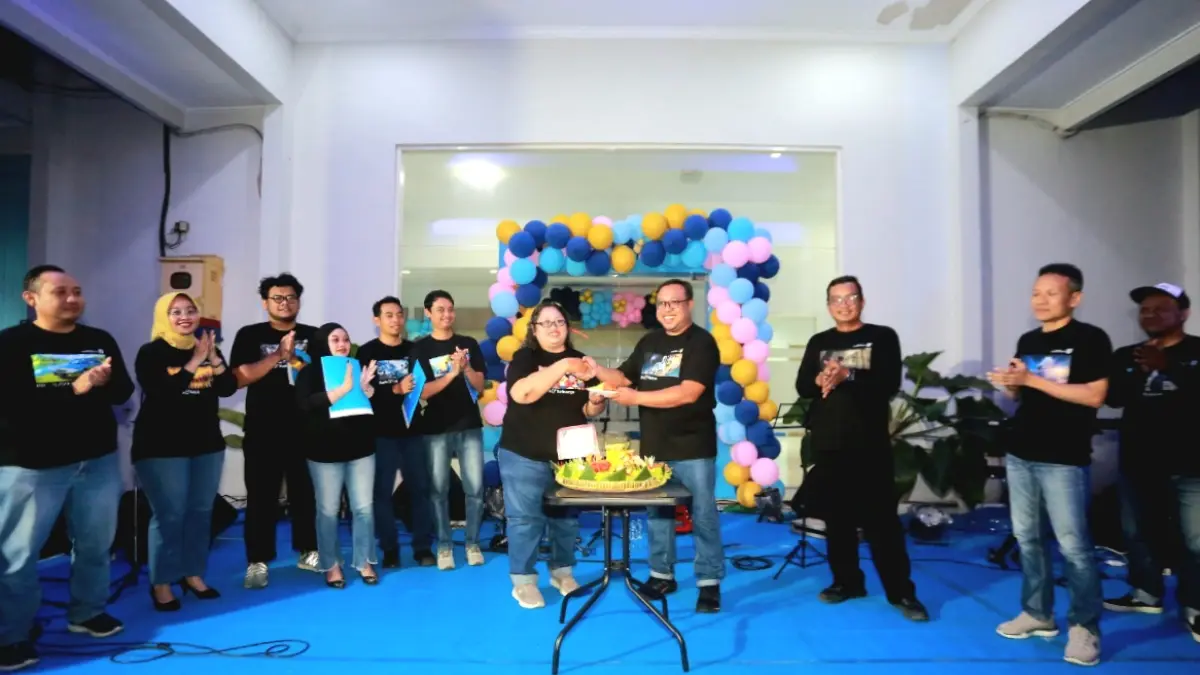 Direktur Jawa Pos Radar Madiun Ockta Prana Lagawira menyerahkan potongan tumpeng kepada perwakilan karyawan. (BAGAS BIMANTARA/RADAR MADIUN)