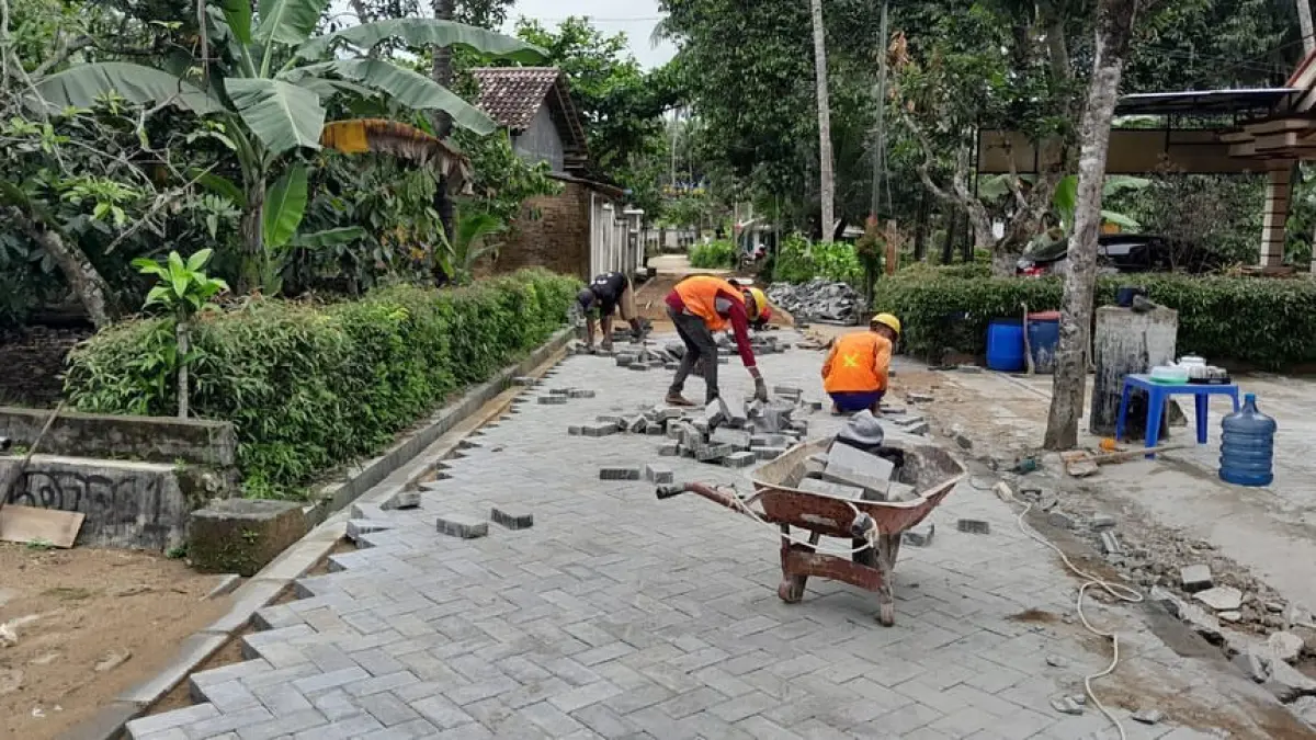 Pekerja melakukan perbaikan jalan lingkungan di kawasan permukiman warga Pacitan. Foto: ISTIMEWA