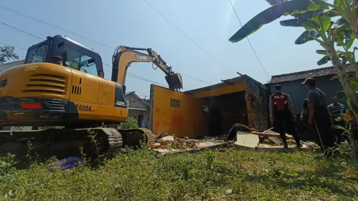 Petugas mengerahkan alat berat untuk mengeksekusi bangunan di atas lahan sengketa seluas 280 meter persegi di Kelurahan Kelun, Kecamatan Kartoharjo, Kota Madiun. HENGKY RISTANTO/RADAR MADIUN