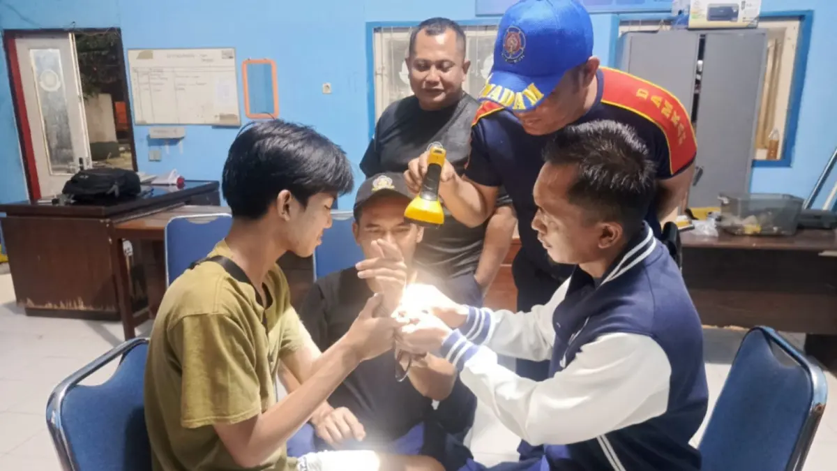 EVAKUASI: Petugas Satpol PP dan Damkar Ponorogo memotong borgol yang mengunci tangan seorang pelajar SMK menggunakan gerinda. FOTO: ISTIMEWA
