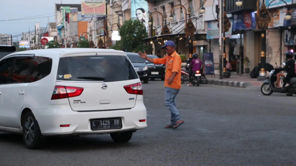 SUMBER PAD: Petugas juru parkir menata kendaraan di kawasan parkir tepi jalan di Ponorogo. SUGENG DWI N/RADAR PONOROGO