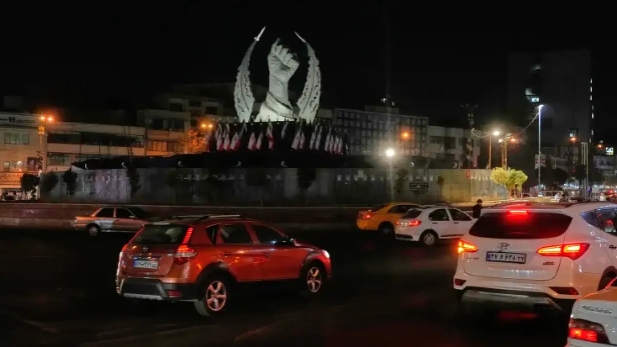 Vehicles drive past a monument depicting the clenched fist of the late Iranian supreme leader, Ayatollah Ali Khamenei, who was killed in a US and Israeli strike on February 28, in Islamic Revolution Square in Tehran, on July 19, 2026 (Al Jazeera)