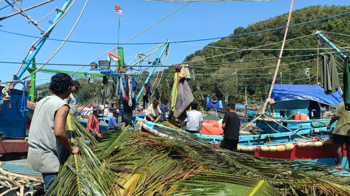 BERSIAP MELAUT: Nelayan di Pacitan memperbaiki jaring sebelum berangkat melaut. NUR CAHYONO/RADAR PACITAN