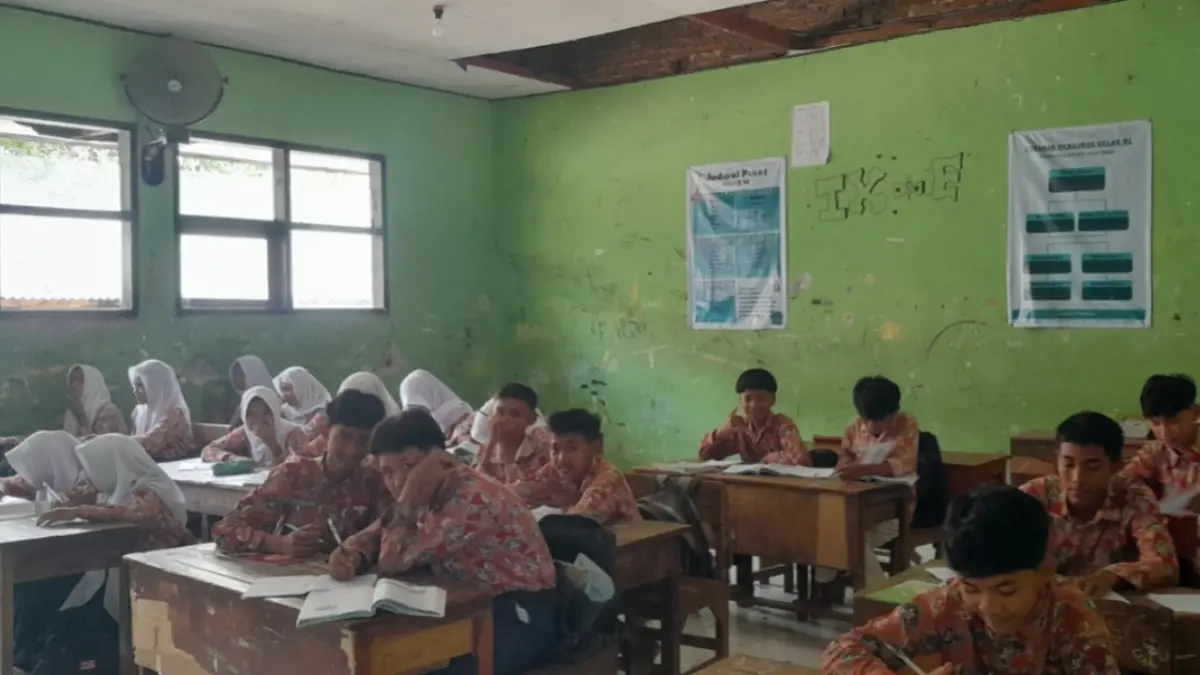 KBM DI TENGAH KERUSAKAN: Siswa SMPN 1 Bringin, Ngawi, tetap mengikuti kegiatan belajar mengajar di ruang kelas yang mengalami kerusakan pada plafon. ASEP SYAEFUL/RADAR NGAWI