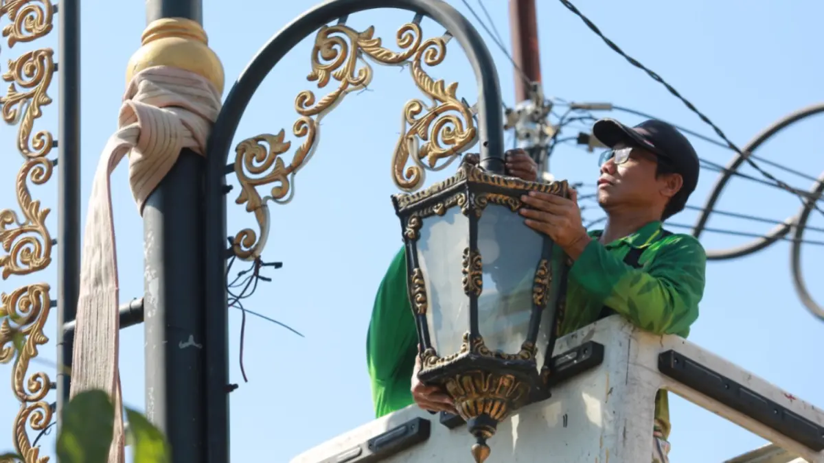JAGA KOTA TETAP TERANG: Petugas Disperkim Kota Madiun melakukan pemeliharaan dan peningkatan kualitas jaringan penerangan jalan umum (PJU) di Kelurahan Patihan. BAGAS BIMANTARA/RADAR MADIUN