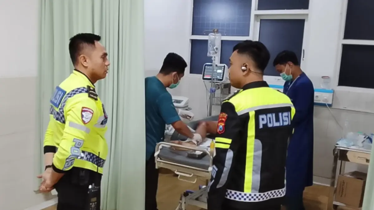 EVAKUASI KORBAN: Petugas Satlantas Polres Pacitan menangani korban kecelakaan yang melibatkan dua sepeda motor di Jalan WR Supratman, Minggu (26/7) dini hari.