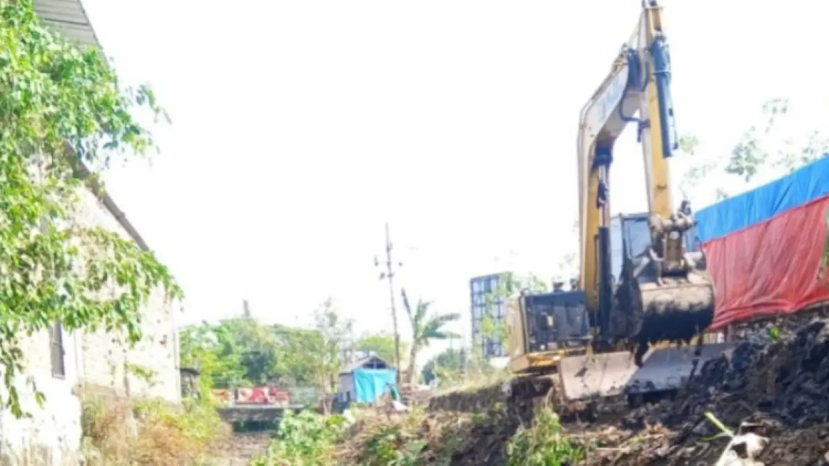 KEBUT NORMALISASI: Alat berat ekskavator milik DPUPR Magetan mengeruk endapan lumpur dan membersihkan tanaman liar di aliran sungai. AJI PUTRA/RADAR MAGETAN