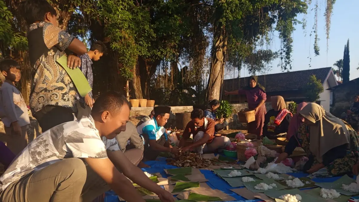 Warga Desa Ngrendeng makan dan doa bersama saat peringatan bersih desa pada Jumat legi Bulan Muharam di punden Ki Ageng Pesuruhan Dusun Ngrendeng.