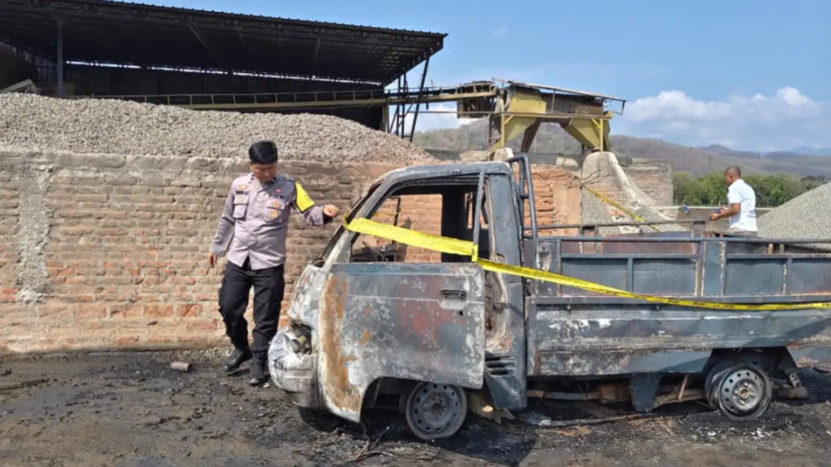 SELIDIKI KEBAKARAN: Polisi memeriksa bangkai pikap Suzuki Carry yang ludes terbakar di area pabrik batu koral, Desa Tegalombo, Kecamatan Kauman.