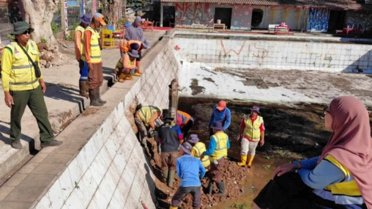 BENAHI ASET: Petugas DPUPR Magetan memperbaiki saluran penguras di kawasan eks Kolam Duta, Plaosan, sebagai langkah awal menghidupkan kembali aset daerah yang telah lama mangkrak. AJI PUTRA/RADAR MAGETAN