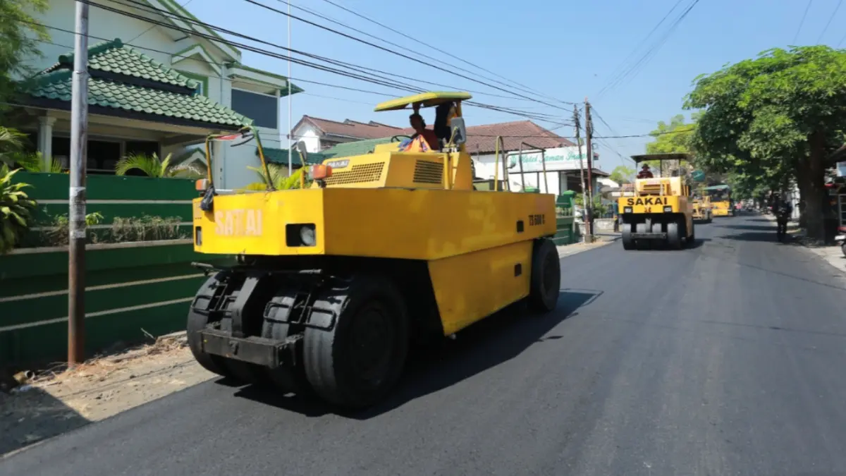 HOTMIX: Pekerja menyelesaikan pengaspalan di salah satu ruas jalan Kota Madiun. FOTO: BAGAS BIMANTARA/JAWA POS RADAR MADIUN