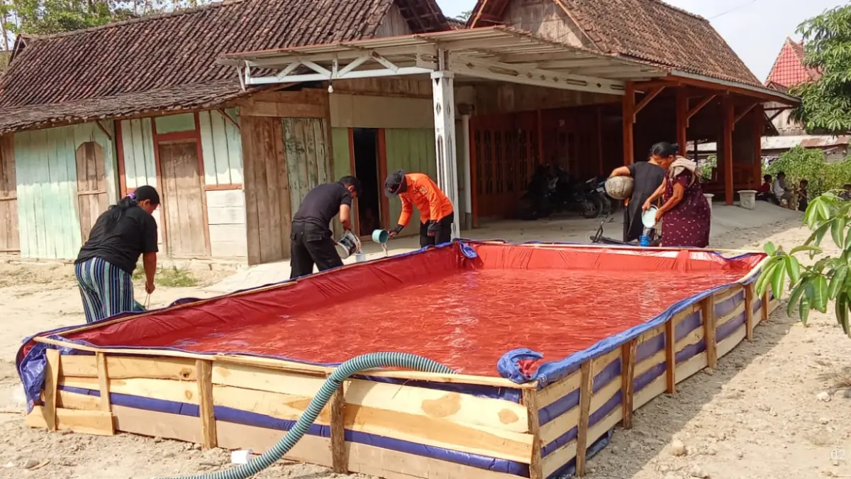 Warga Dusun Gandu, Kecamatan Ngawi, mengambil air dari sumber di kawasan hutan akibat sumur mengering. BPBD terus menyalurkan bantuan air bersih ke wilayah terdampak. Foto: Asep Syaeful Bachri/Jawa Pos Radar Ngawi