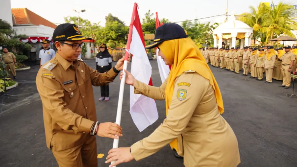 Plt Wali Kota Madiun F. Bagus Panuntun menyerahkan simbolis bendera Merah Putih untuk dibagikan kepada masyarakat menjelang HUT RI ke-81. Foto: WS Hendro/Diskominfo untuk Radar Madiun